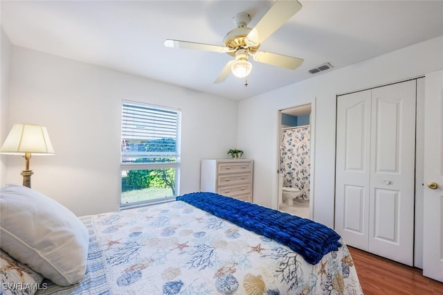 bedroom with ensuite bathroom, hardwood / wood-style floors, ceiling fan, and a closet