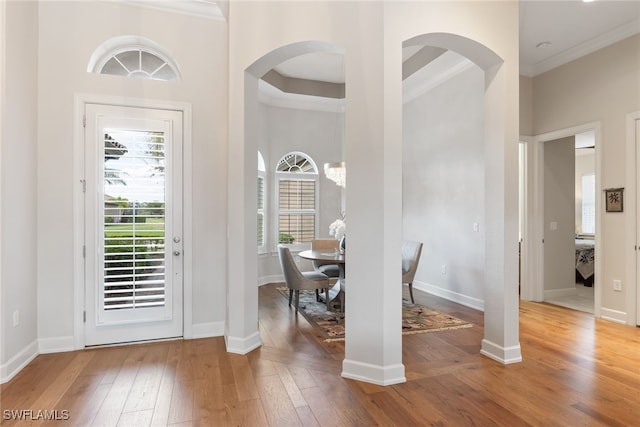 interior space featuring hardwood / wood-style floors, crown molding, plenty of natural light, and a high ceiling