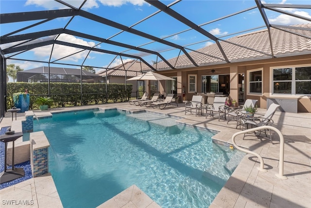 view of pool featuring a patio area, pool water feature, ceiling fan, and glass enclosure