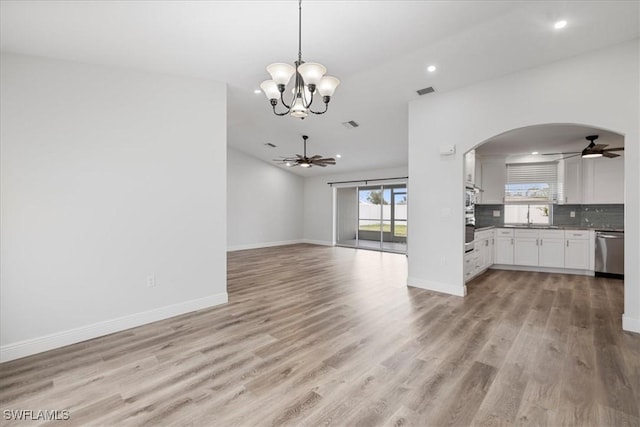 unfurnished living room featuring light wood-type flooring, baseboards, and ceiling fan with notable chandelier