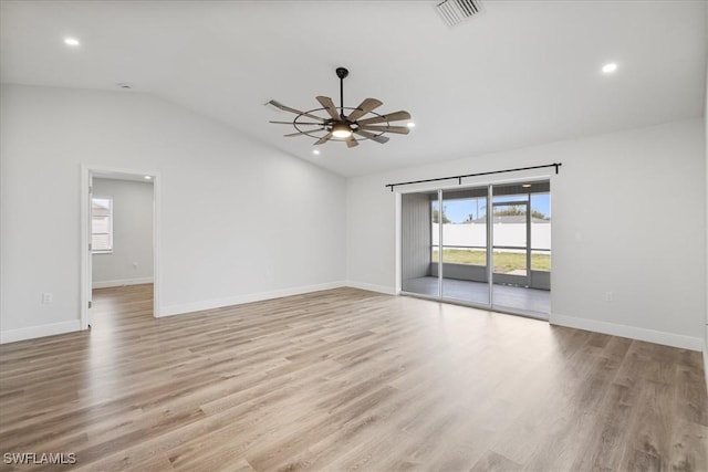 spare room featuring lofted ceiling, light wood-type flooring, visible vents, and ceiling fan