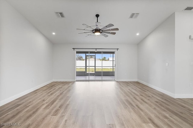 unfurnished room with light wood finished floors, baseboards, and visible vents