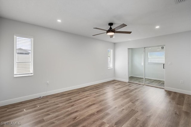 unfurnished bedroom with recessed lighting, wood finished floors, a ceiling fan, baseboards, and a closet