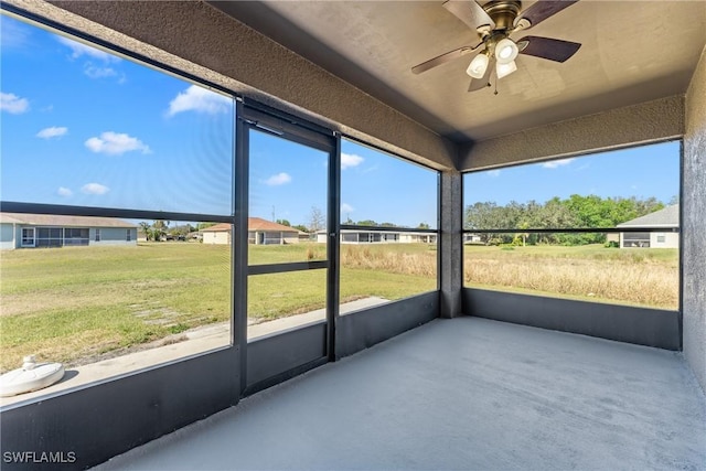 unfurnished sunroom featuring a wealth of natural light and ceiling fan