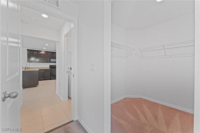 spacious closet with light tile patterned floors and sink