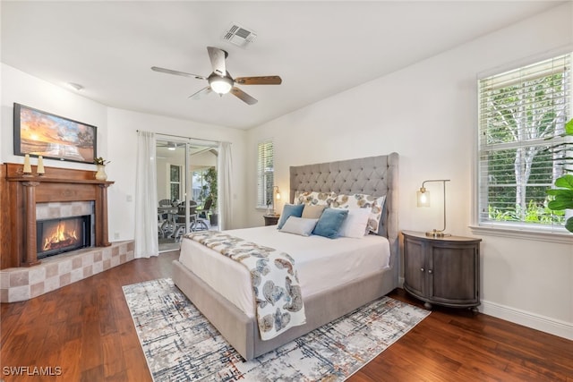 bedroom featuring a fireplace, visible vents, dark wood-type flooring, access to outside, and baseboards