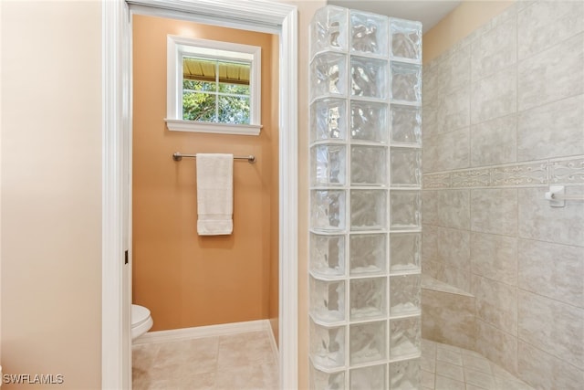 full bathroom with a walk in shower, tile patterned flooring, toilet, and baseboards