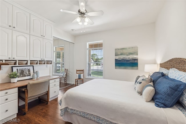 bedroom with built in desk, dark wood-style flooring, and a ceiling fan