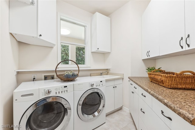 laundry room featuring cabinet space, light tile patterned floors, a sink, and independent washer and dryer