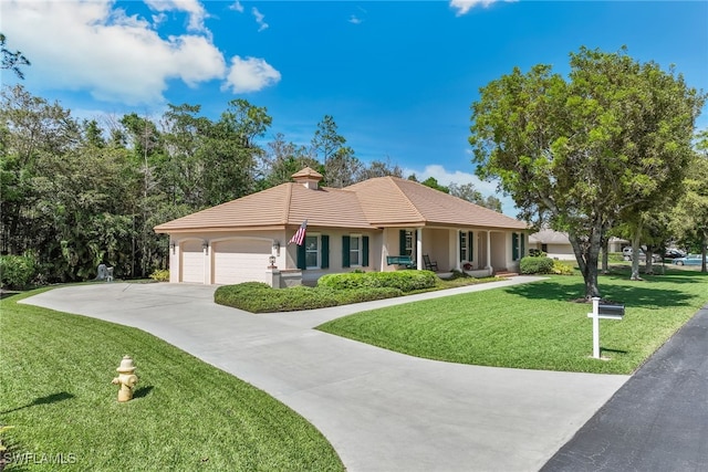 view of front facade with driveway, a garage, a tiled roof, a front yard, and stucco siding