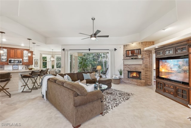 living room featuring a fireplace and ceiling fan