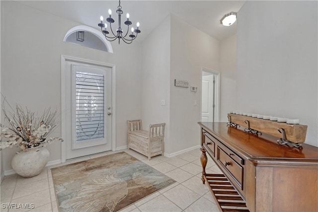 tiled entryway with a towering ceiling and an inviting chandelier