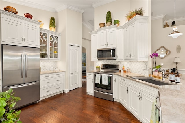 kitchen featuring crown molding, decorative light fixtures, stainless steel appliances, and white cabinets