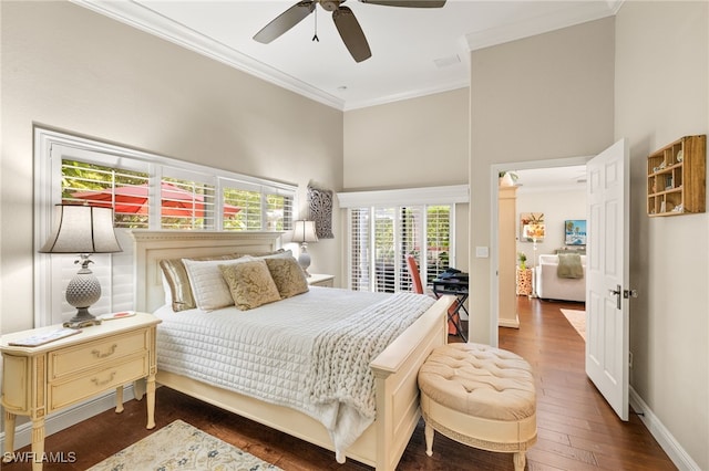 bedroom with a towering ceiling, dark wood-type flooring, ornamental molding, and ceiling fan