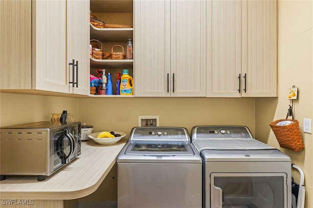 laundry room with cabinets and washer and clothes dryer