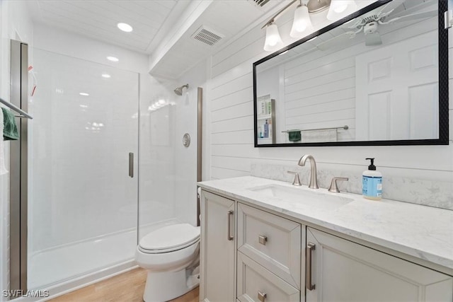 bathroom with wood walls, hardwood / wood-style flooring, vanity, walk in shower, and toilet