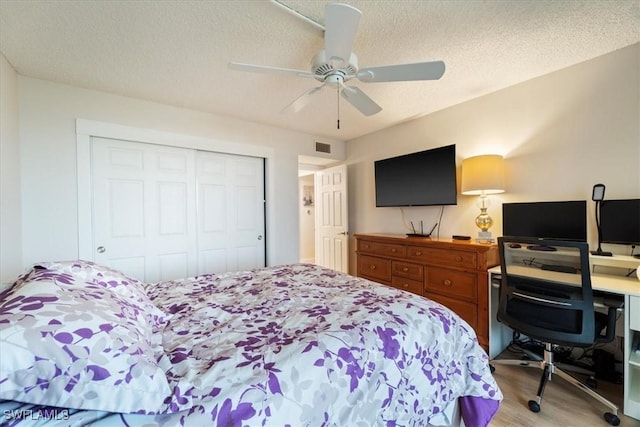 bedroom featuring ceiling fan, light hardwood / wood-style floors, a textured ceiling, and a closet