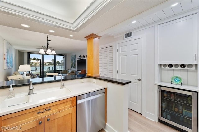 kitchen with decorative columns, sink, wine cooler, stainless steel dishwasher, and light hardwood / wood-style floors