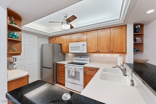 kitchen with ceiling fan, sink, white appliances, and kitchen peninsula