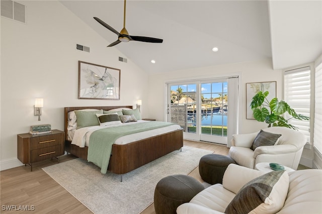 bedroom with multiple windows, high vaulted ceiling, access to outside, and light hardwood / wood-style floors