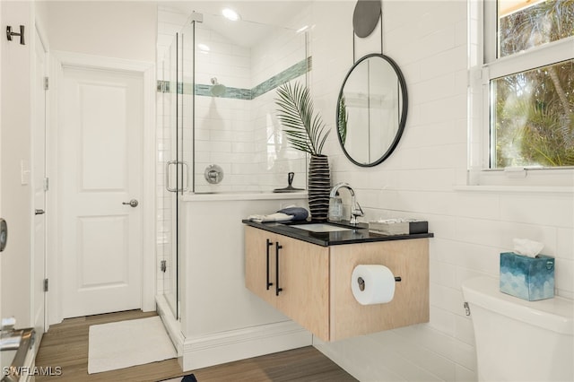 bathroom with vanity, hardwood / wood-style floors, a shower with shower door, and toilet