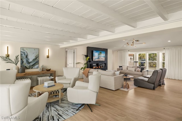 living room with beamed ceiling, wood ceiling, radiator, and light hardwood / wood-style floors