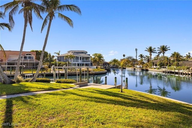 view of dock with a water view and a yard