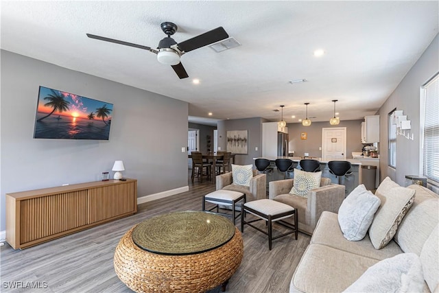 living room featuring hardwood / wood-style flooring and ceiling fan