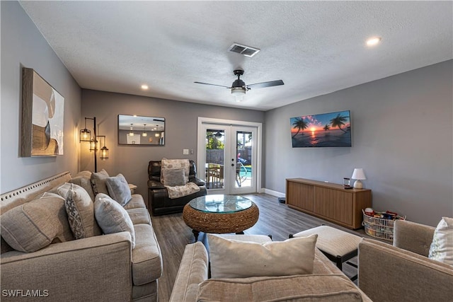 living room featuring ceiling fan, dark hardwood / wood-style floors, a textured ceiling, and french doors