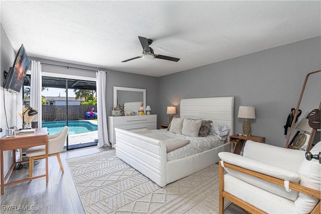 bedroom featuring ceiling fan, light hardwood / wood-style floors, a textured ceiling, and access to outside