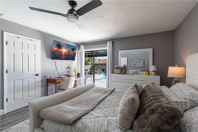 bedroom featuring ceiling fan, light hardwood / wood-style floors, a textured ceiling, and access to outside