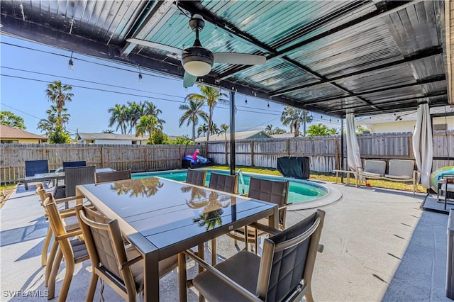 view of patio / terrace featuring ceiling fan and a fenced in pool