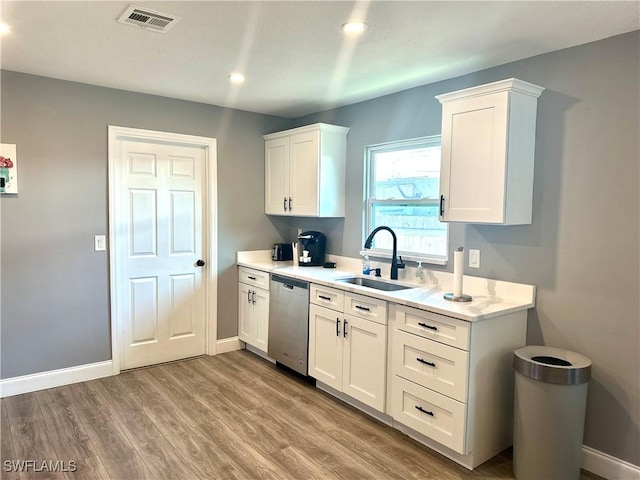 kitchen featuring sink, white cabinets, dishwasher, and light wood-type flooring