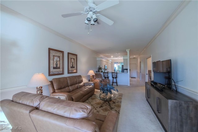 living room featuring light carpet, ornamental molding, decorative columns, and ceiling fan