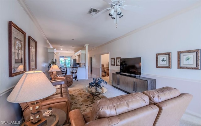 living room with light carpet, ornamental molding, ceiling fan, and ornate columns