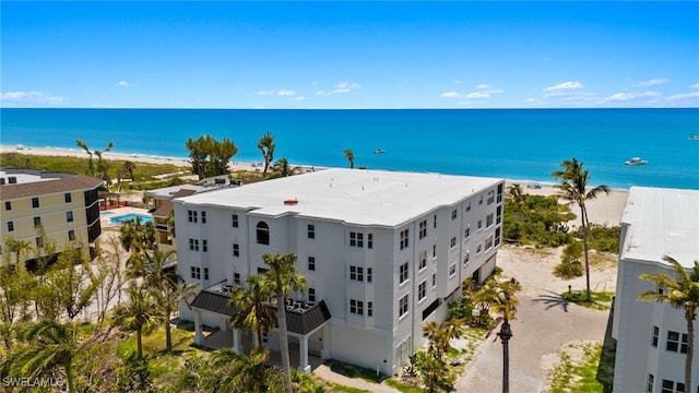 drone / aerial view featuring a beach view and a water view