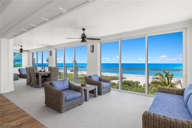 sunroom featuring a water view, a beach view, and ceiling fan