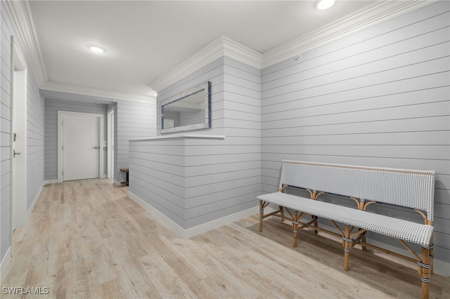 hall with light hardwood / wood-style flooring and ornamental molding