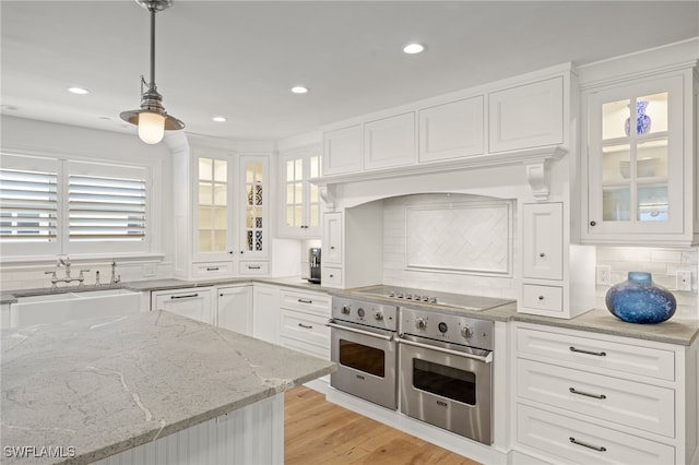 kitchen featuring oven, white cabinets, and decorative light fixtures