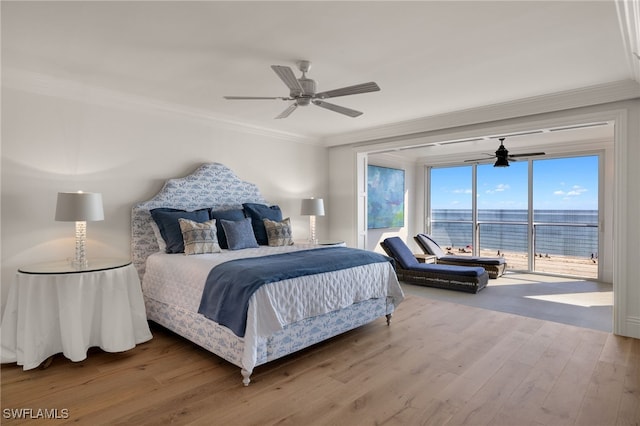 bedroom featuring crown molding, access to outside, wood-type flooring, and a water view