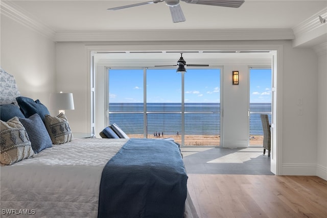 bedroom featuring ornamental molding, a water view, access to outside, and light wood-type flooring