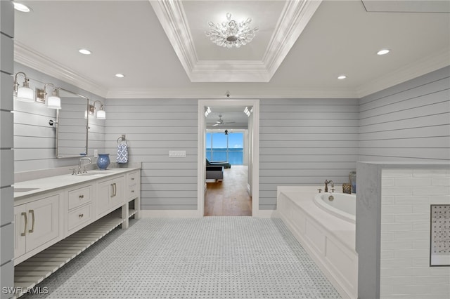 bathroom with crown molding, a tub to relax in, a tray ceiling, and vanity