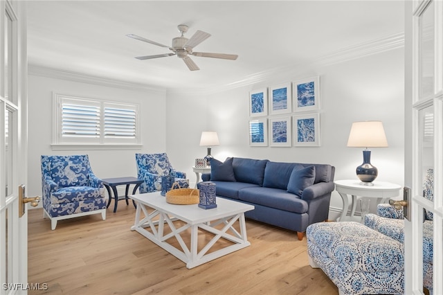 living room featuring ornamental molding, ceiling fan, and light wood-type flooring