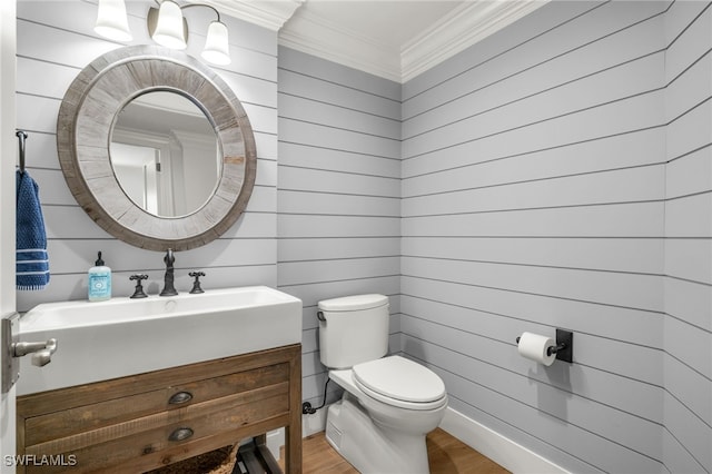 bathroom with ornamental molding, toilet, wood-type flooring, and vanity