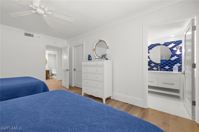 bedroom featuring ceiling fan, ornamental molding, ensuite bath, and light wood-type flooring