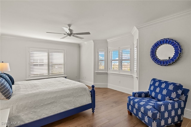 bedroom featuring hardwood / wood-style flooring, ornamental molding, and ceiling fan