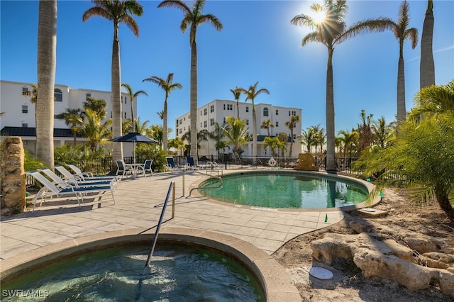 view of pool with a community hot tub and a patio area