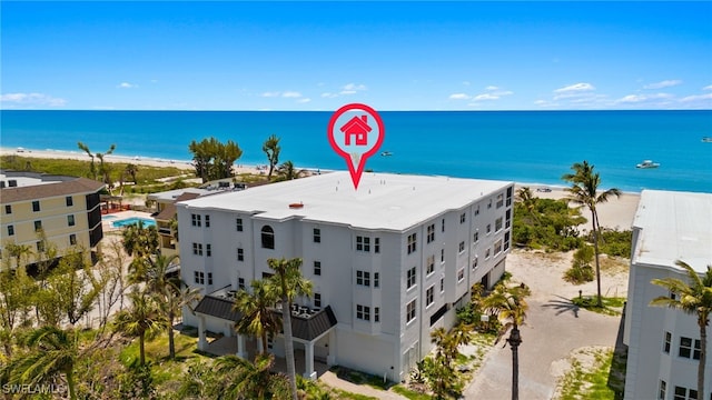 drone / aerial view featuring a water view and a beach view