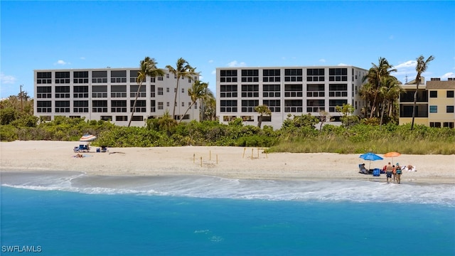 view of swimming pool featuring a view of the beach and a water view