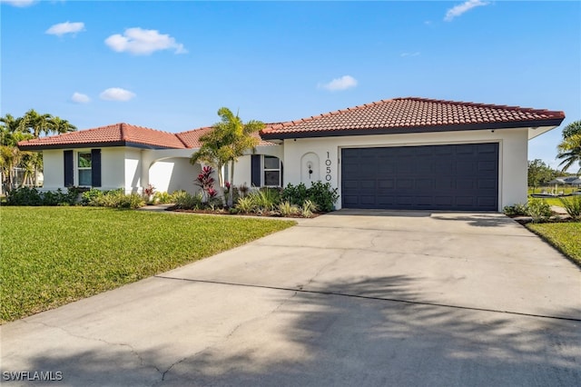 mediterranean / spanish-style house featuring a garage and a front lawn